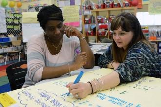Two teachers looking at chart paper together